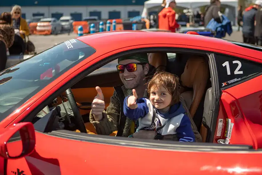 Moment de partage en famille lors d’une expérience de sport automobile adaptée sur circuit