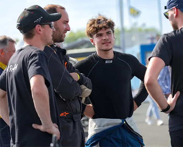 eunes pilotes de Formule 4 en discussion avec leur encadrement dans le paddock, lors d’une épreuve du championnat de France